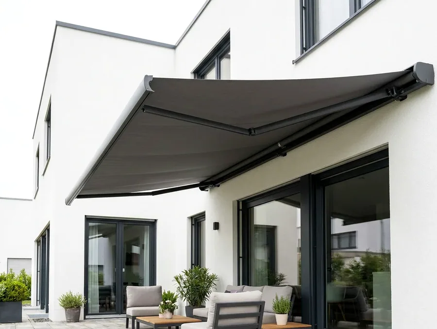 Folding-arm awning extended over a patio lounge and braai area